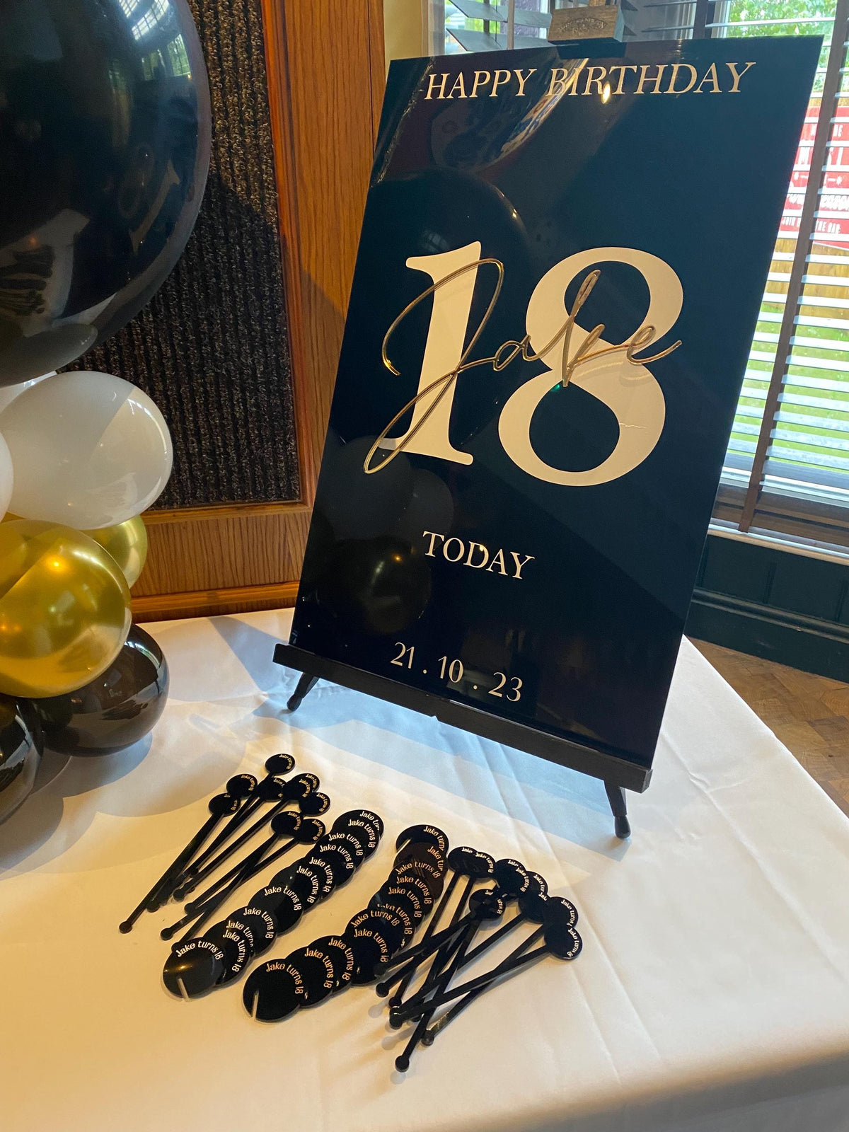 18th birthday welcome sign with matching decorative items on a table