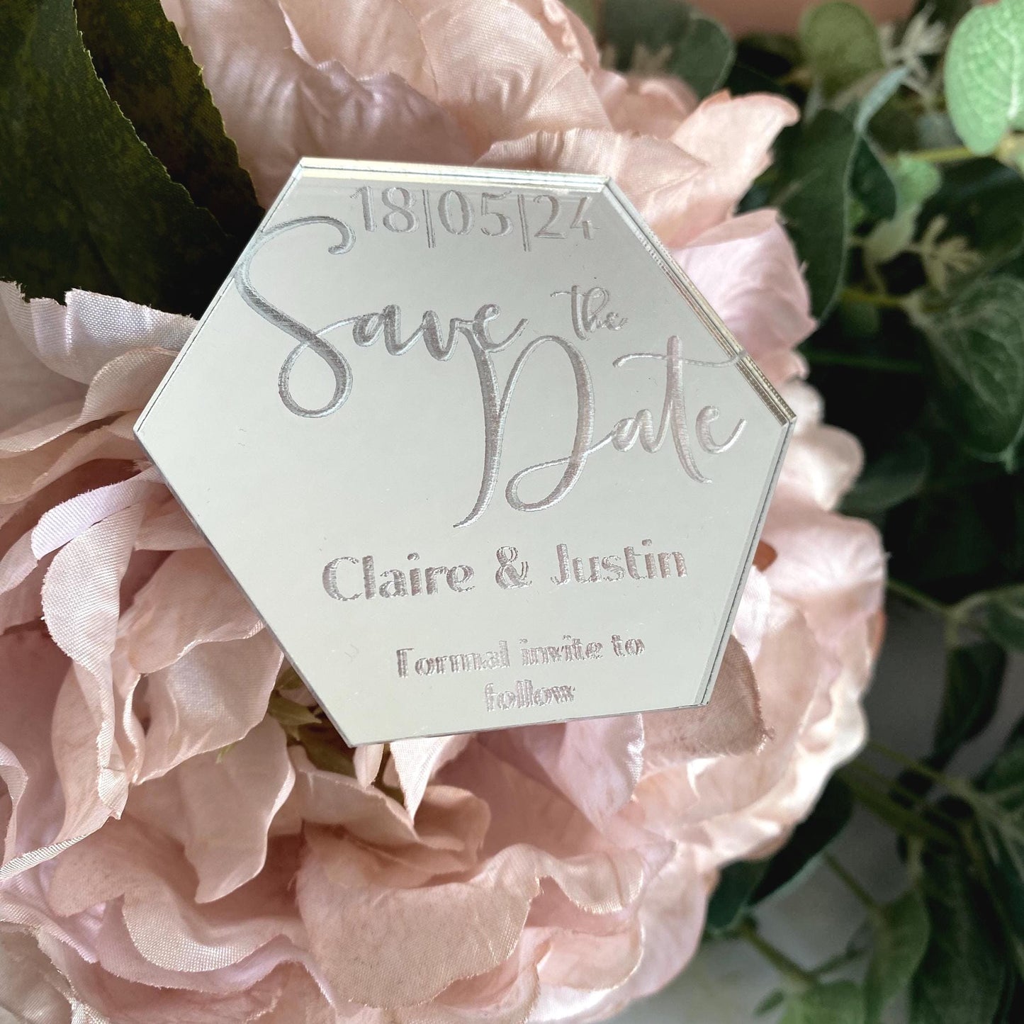 Hexagonal 'Save the Date' card on pink flowers