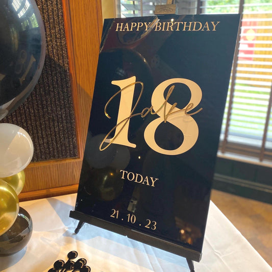 Happy 18th birthday Acrylic Welcome Sign on a stand with decorative items in the background