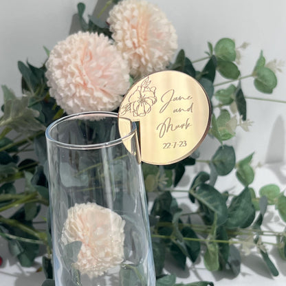 A mirror gold wedding place setting with engraved peony detail and bridal couples names and wedding date.