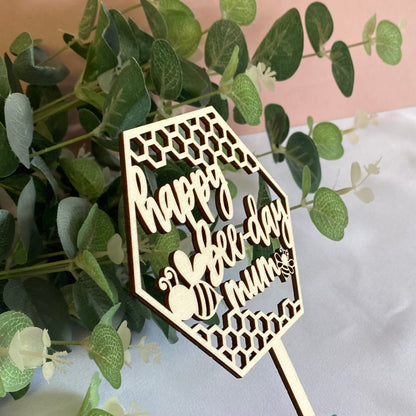 Wooden Cake Topper in a hexagon shape with honeycomb and bee details.