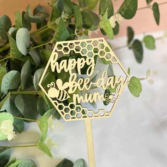 Wooden Cake Topper in a hexagon shape with honeycomb and bee details.