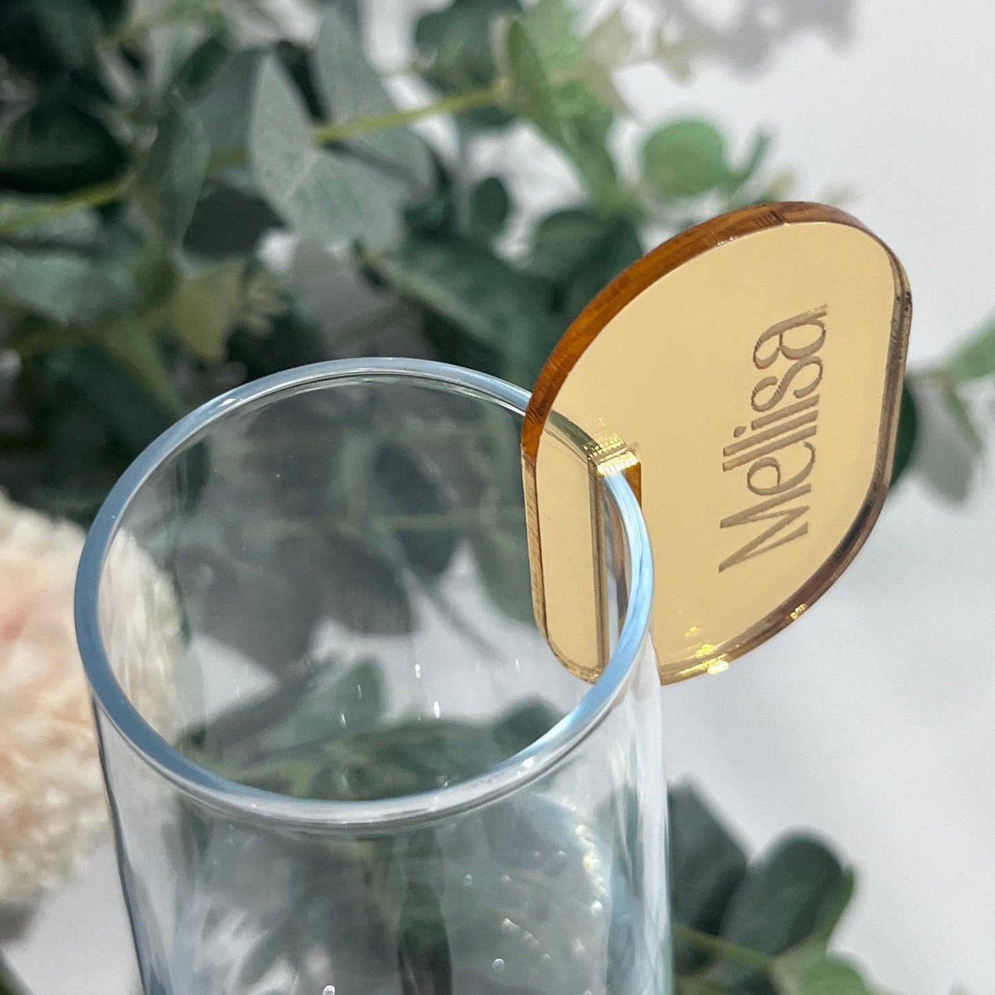 Wedding Place Name that slots on to a wine glass in gold mirror acrylic with the name Melissa engraved in to it