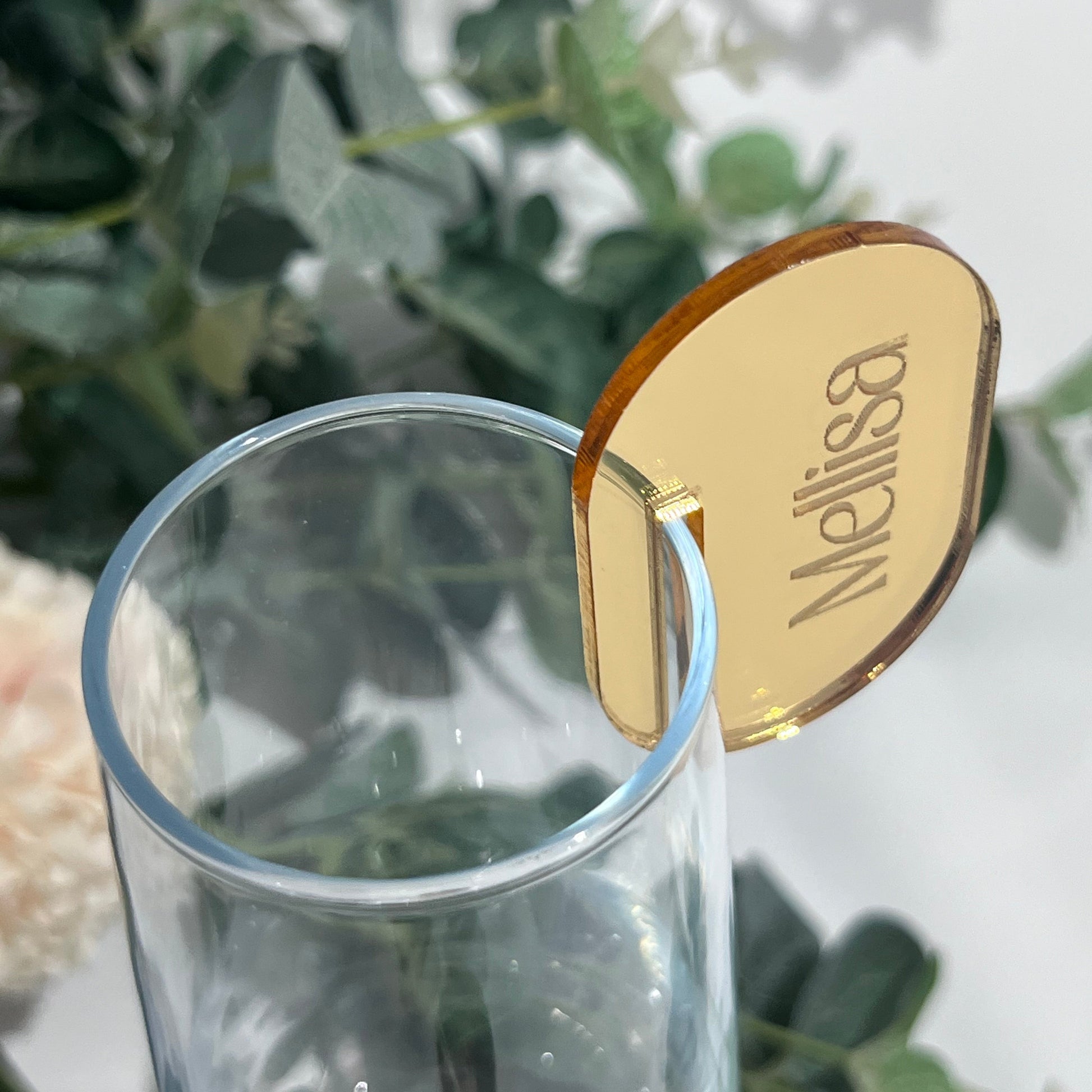 Wedding Place Name that slots on to a wine glass in gold mirror acrylic with the name Melissa engraved in to it