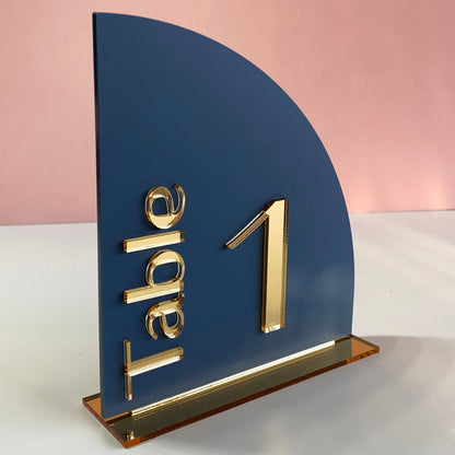 Decorative wedding table number with gold text on a matt navy blue acrylic background